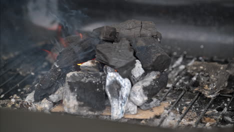 Slow-motion-of-burning-charcoal-with-a-flame-and-smoke-coming-out