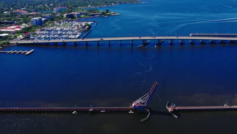Daytime-aerial-over-the-scenic-waterfront-of-Bradenton,-Florida,-the-CSX-Train-Bridge-stands-as-an-engineering-marvel