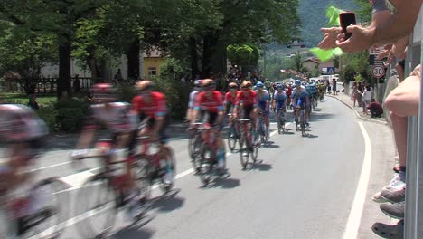 Cyclists-racing-through-town-Tolmin-at-tour-of-slovenia,-fans-cheering-by-road