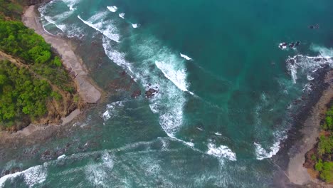 Flying-down-onto-a-gap-in-the-land-of-Playa-Herradura-in-Costa-Rica-to-reveal-the-rough-beautiful-terrain-along-the-coast