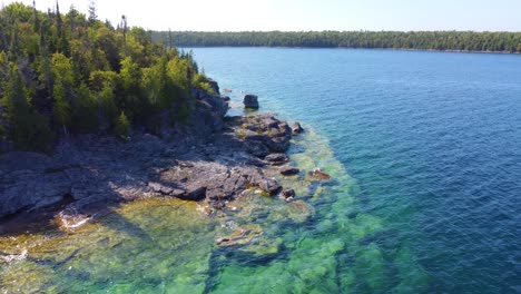 Drone-shot-of-blue-clearly-water-in-the-coast-of-Georgian-Bay,-Ontario,-Canada