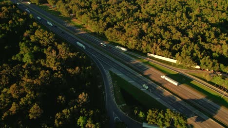 Aerial-of-semi-truck-rest-area-in-Florida-with-highway,-long-haul-truckers-and-travelers-passing-through-the-Sunshine-State