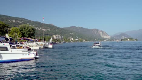 Un-Barco-Turístico-Que-Sale-Y-Otro-Que-Llega-Al-Punto-De-Atraque-En-El-Lago-Maggiore