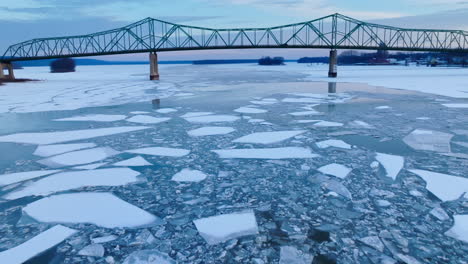 A-breathtaking-drone's-eye-view-of-colossal-ice-chunks-in-the-water-with-bridge-in-view