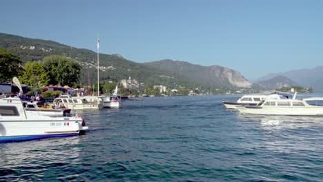 Ein-Ausflugsboot-Fährt-Ab-Und-Ein-Anderes-Kommt-An-Der-Anlegestelle-Am-Lago-Maggiore,-Stresa,-Piemont,-Italien-An