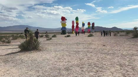 Tourists-visiting-art-installation-in-the-desert-of-Nevada,-the-Seven-Mountains