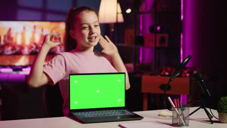 Child-tech-content-creator-filming-technology-review-of-green-screen-laptop