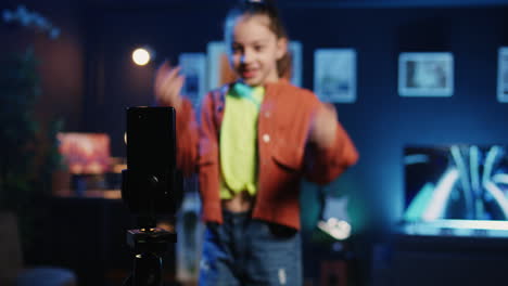 Focus-shot-on-smartphone-on-tripod-used-by-kid-in-blurry-background-doing-viral-dance-choreography