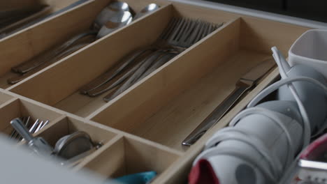 Emptying-the-dishwasher-and-putting-the-silverware-into-a-drawer