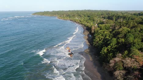 Costa-Rica-beach-drone-view-showing-sea,-shore-and-a-stranded-ship-on-a-sunny-day-over-the-atlantic-ocean-in-the-caribbean