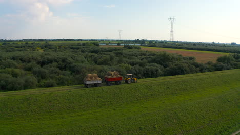 Aerial-view-of-drone-flying-above-farmland-with-tractor-on-the-field