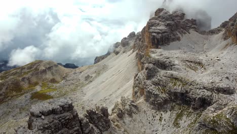 High-mountain-ridge,-rugged-terrain-of-Dolomites-and-massive-white-clouds