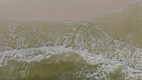 Aerial-hover-of-calm-waves-crashing-on-the-beach-at-Cape-San-Blas,-Florida