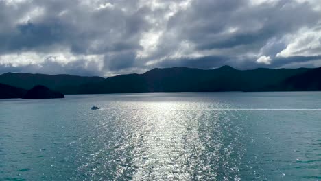 Boat-crossing-channel-under-dark-clouds,-Cook-Strait,-New-Zealand
