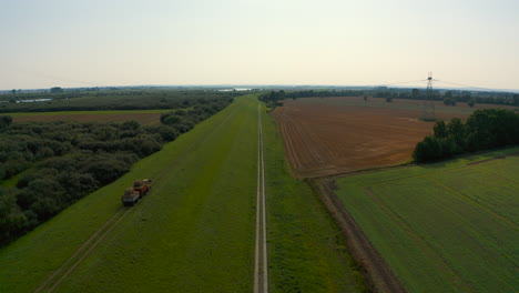 Vista-Aérea-De-Drones-Volando-Sobre-Tierras-De-Cultivo-Con-Tractor-En-El-Campo