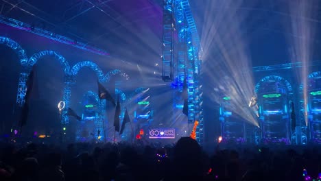 Crowd-dances-under-flashing-lights-and-visuals-at-music-festival-stage