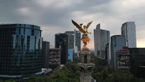 Drone-video-of-the-Angel-of-Independence,-surrounded-by-the-buildings-of-Paseo-de-la-Reforma,-Mexico-City