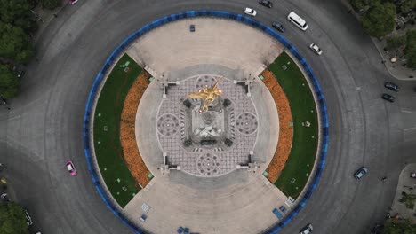 Drone-video-of-the-Angel-of-Independence,-cars-pass-along-Paseo-de-la-Reforma-avenue-and-the-roundabout-where-the-monument-is-situated