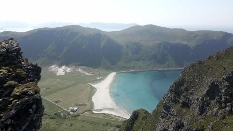 Aerial-revealing-shot-showing-Hoddevik-Beach-and-mountains-with-blue-sea-during-sunny-day,-Norway---top-down