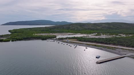 Aufsteigende-Drohnenaufnahme-Von-Verankerten-Booten-An-Der-Playa-Tortuguero-Und-Bergen-Im-Hintergrund