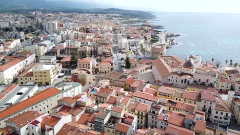 Aerial-shot-over-Alghero-old-town,-Sardinia,-with-cityscape-view-on-a-beautiful-clear-day
