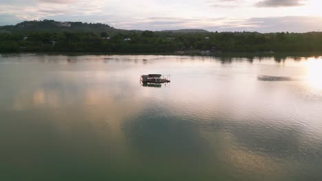 Luftaufnahme-Eines-Schwimmenden-Cottage-Resorts-In-Einer-Ruhigen-Bucht-Bei-Sonnenuntergang,-Philippinen