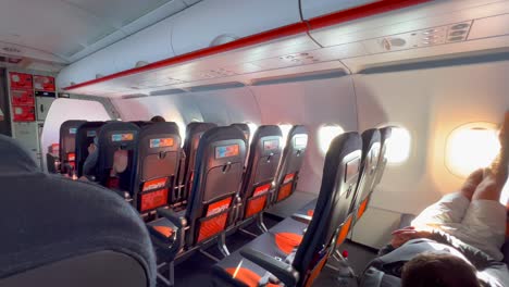 A-person-sleeping,-chilling-relaxing-and-laying-down-with-legs-up-on-Easyjet-airplane-window-seats,-Easyjet-flying-experience-at-an-airport,-people-going-on-a-holiday,-4K-shot