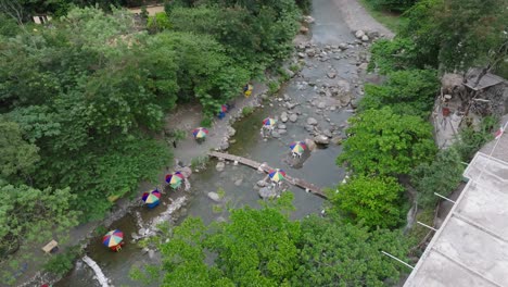 Aerial-top-down-shot-of-Rio-Bani-river-with-sunshade-and-table-on-rock-,-Dominican-Republic