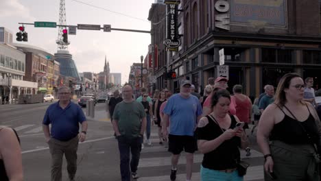 People-walking-on-sidewalk-along-Broadway-Street-in-Nashville,-Tennessee-in-slow-motion