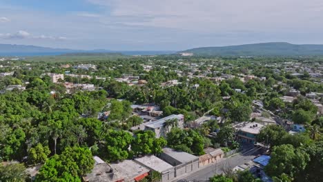 Sobrevuelo-Aéreo-Del-Pueblo-De-Azua-Con-árboles-Verdes-Y-Edificios-Antiguos-En-República-Dominicana-En-Un-Día-Soleado