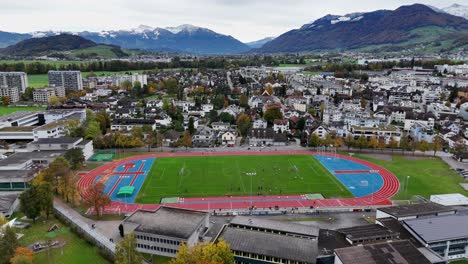 swiss-outdoor-sports-centre,-athletic-court-drone-zoom-out-Lachen-Swiss-city