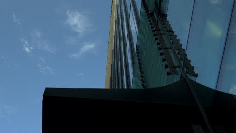 Upward-view-of-modern-skyscraper-with-detailed-facade-against-blue-sky