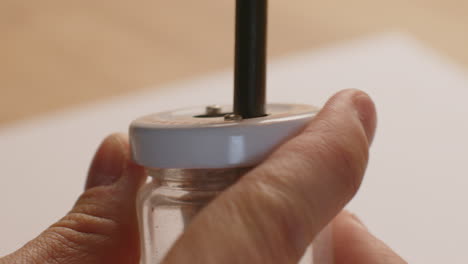 Makroaufnahme-Der-Verwendung-Eines-Bleistiftspitzers-Mit-Der-Linken-Hand
