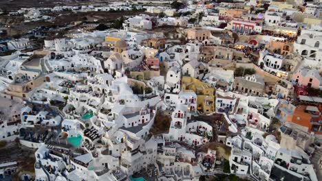 Casas-Y-Hoteles-Junto-Al-Acantilado-Del-Pueblo-De-Oia-En-Santorini,-Grecia,-Vista-Aérea-Cinematográfica