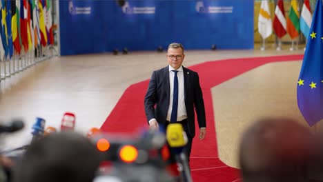 Finish-Prime-Minister-Petteri-Orpo-arriving-on-the-red-carpet-at-the-European-Council-summit-in-Brussels,-Belgium---Slow-motion