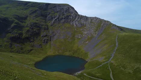 Aerial-4K-drone-video-of-mountain-tarn-in-caldera-with-sharp-ridge---Scales-Tarn,-Sharp-Edge,-Lake-District-UK