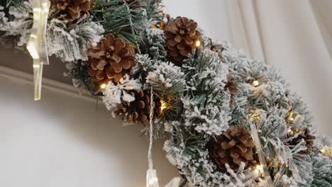 Verschneiter-Weihnachtskranz-Mit-Lichtern-Und-Tannenzapfen