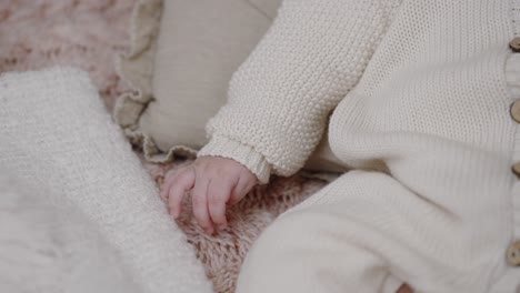 Infant-baby-hand-on-knitted-blanket.-Close-Up