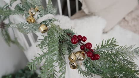Frosted-pine-decoration-with-golden-bells-and-red-berries