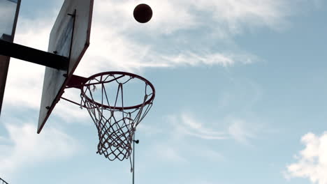 Mann-Wirft-Draußen-Einen-Basketball-Gegen-Einen-Blauen-Himmel