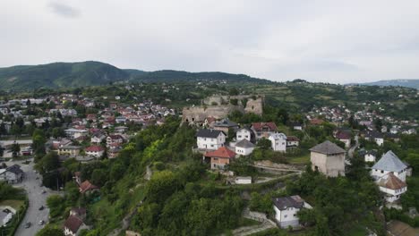 Jajce-citadel-aerial-view-orbiting-walled-city-stronghold-with-mount-Orjen-mountain-landscape,-Bosnia