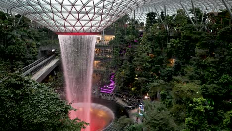 Blick-Aus-Der-Vogelperspektive-Auf-Den-Rot-Beleuchteten-Regenwirbel-Wasserfall-Am-Jewel-Changi-Airport-Singapur