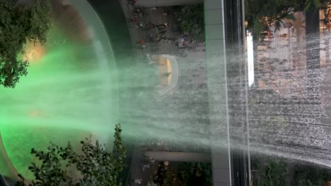 The-Magnificent-Rain-Vortex-Waterfall-Located-At-Jewel-Changi-Airport-With-Green-Light-Glow