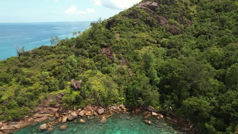 Drone-reveal-of-forest-from-gazebo-view-point-at-Anse-major-beach,-over-national-and-marine-park,-granite-stones-and-turquoise-water,-Mahe-Seychelles,-30-fps