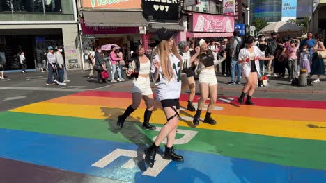Teens-are-dancing-while-someone-is-filming-them-on-the-rainbow-painted-street-of-Ximending,-a-shopping-district-in-Taipei,-Taiwan