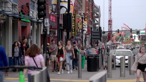 People-walking-along-Broadway-Street-in-Nashville,-Tennessee-in-slow-motion
