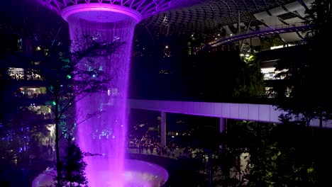 Purple-Illuminated-Indoor-Waterfall-At-Jewel-Changi-Airport-Singapore-In-The-Evening