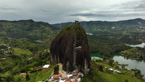 Drone-shot-around-the-Piedra-del-Peñol-monolith,-in-cloudy-Guatape,-Colombia