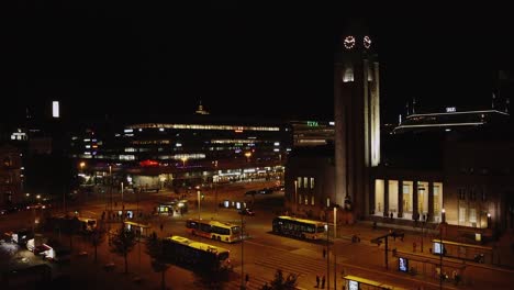 Night-aerial-rises-in-Railway-Square-in-downtown-Helsinki,-city-life