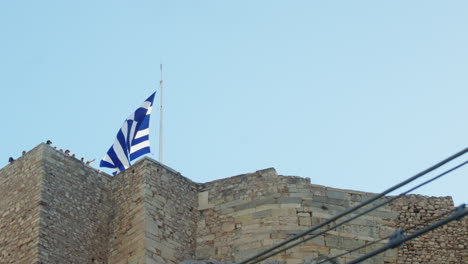 Greek-flag-waving-atop-an-ancient-stone-fortress